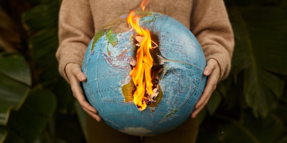 a person wearing a brown sweater holding a burning globe